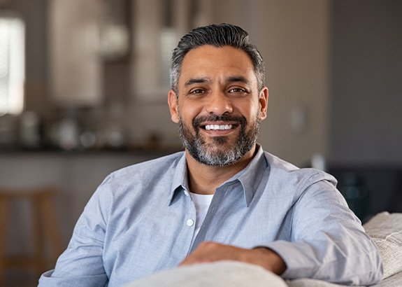 Man smiling while sitting in couch at home