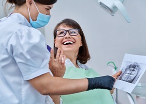 Dentist reviewing X-ray with smiling patient