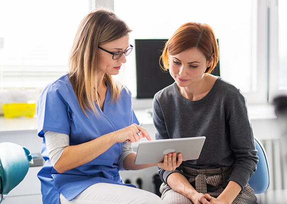 Dental team member showing a tablet to a patient