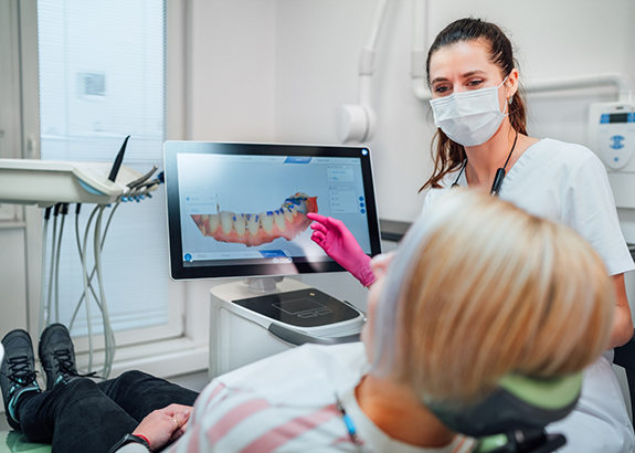 Dentist showing a patient a digital impression of her teeth on a monitor