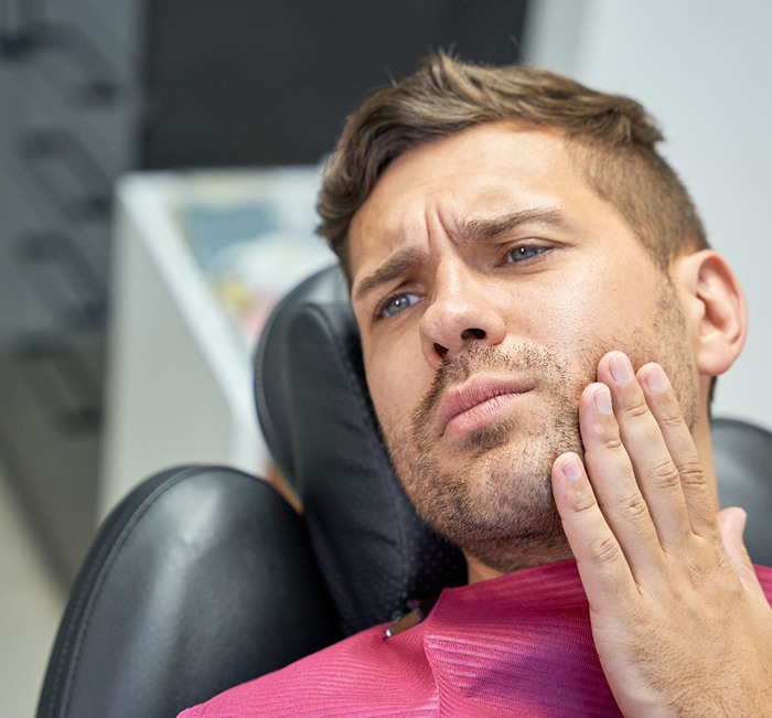 Patient with toothache sitting in treatment chair