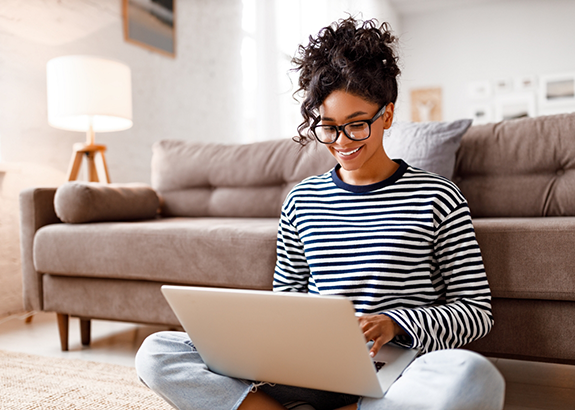 Woman smiling while typing on her laptop