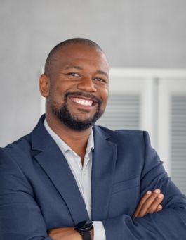 Man in a suit smiling with his arms crossed