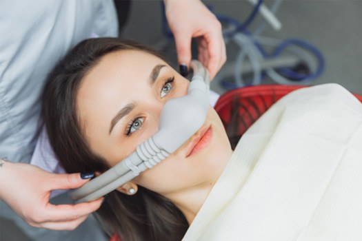 Hands placing nitrous oxide mask over patient’s nosey