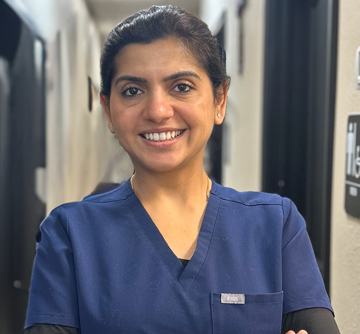 Brenham dentist Doctor Saru Sharma smiling in blue scrubs