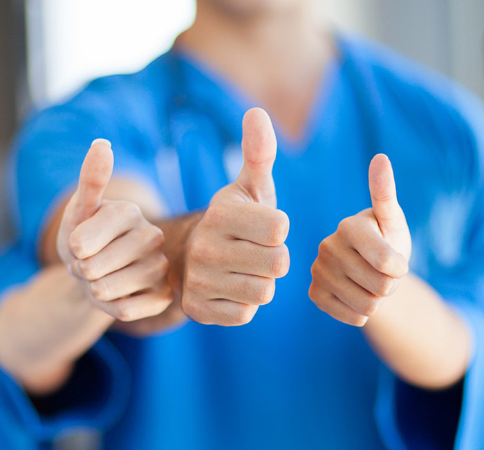 Three Brenham dental team members giving thumbs up