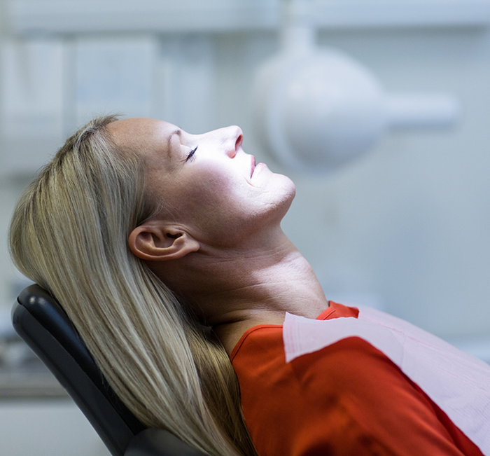 Woman relaxing in the dental chair because of sedation dentistry in Brenham