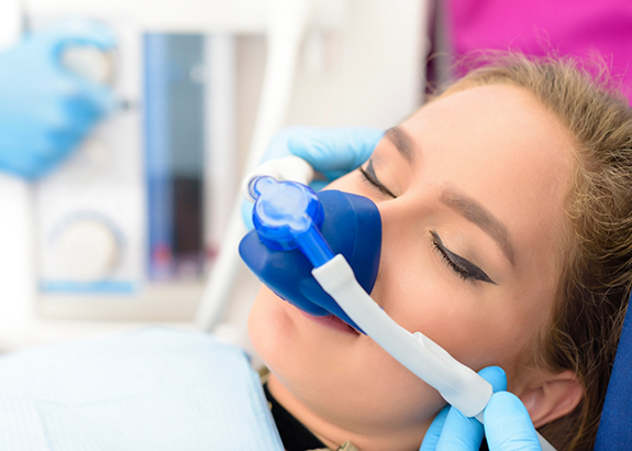 Woman in dental chair with a nitrous oxide mask over her nose