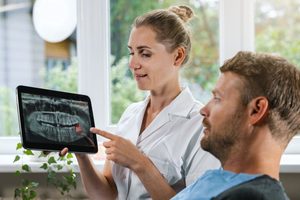 Dentist explaining X-ray that shows wisdom tooth